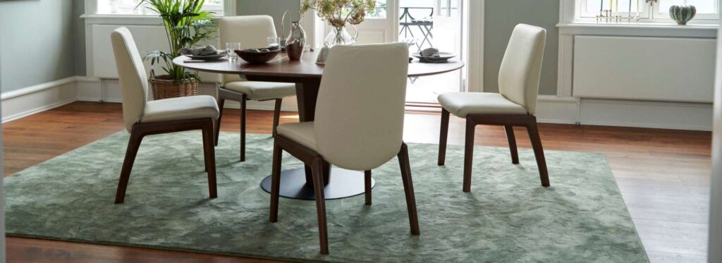 Stressless Laurel Dining Chairs around a table in Paloma leather