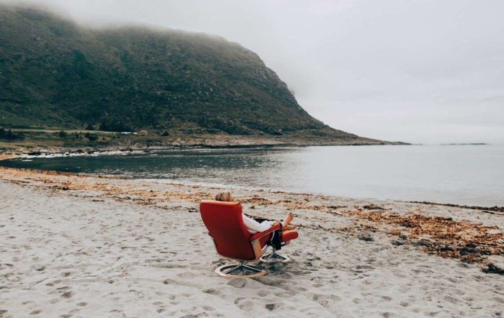 Person sitting in Stressless recliner by a fjord in Norway