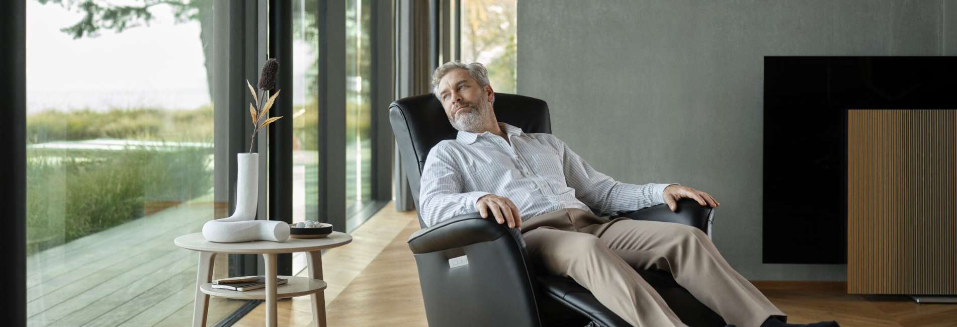 man laying back in a recliner looking out the window